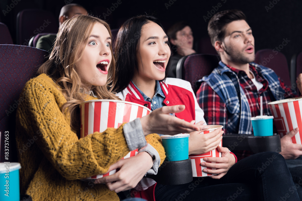 Watching an exciting movie. Attractive young woman drinking soda while  watching movie at the cinema Stock Photo by gstockstudio