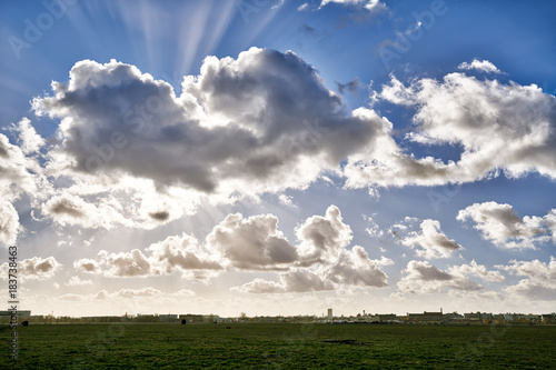 dramatic sky and meadow with the skyline of Berlin