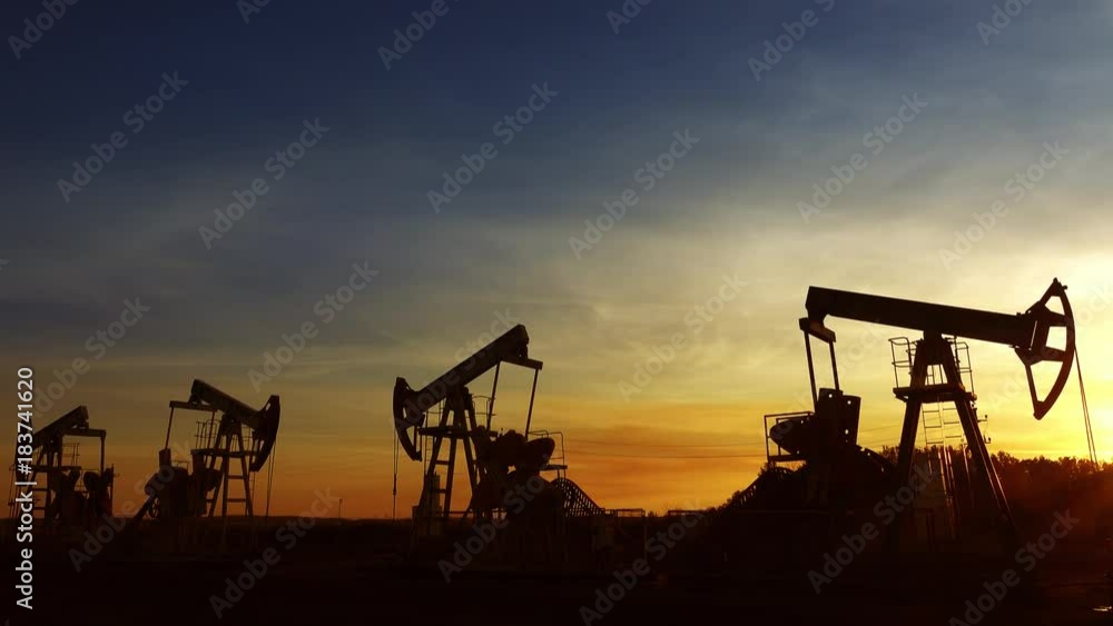 many working oil pumps silhouette against sunset, 4k
many working oil pumps silhouette against sunset, 4k
