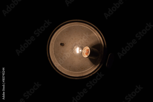 Old dirty lamp with bulb on black background