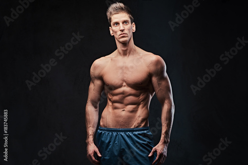Shirtless muscular male over dark background. © Fxquadro