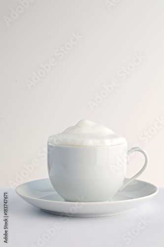 Milchschaum in einer Kaffeetasse auf weißem Hintergrund