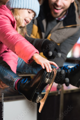 selective focus of happy father and daughter wearing skates on rink © LIGHTFIELD STUDIOS