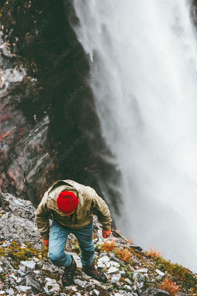 Obraz premium Man climbing in mountains waterfall on background outdoor Travel Lifestyle survival concept adventure vacations wild nature landscape