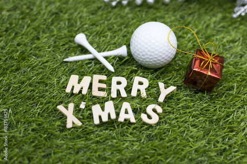Merry Christmas and Happy New year to golfer on green grass with ornament