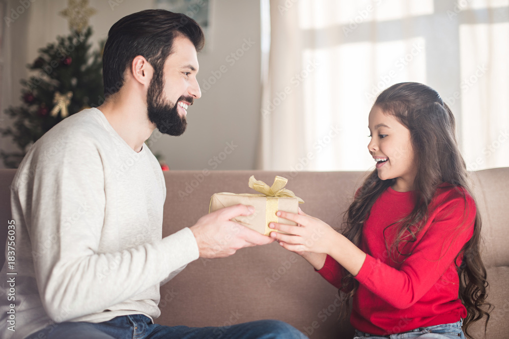 smiling father presenting gift box to daughter smiling father presenting gift box to daughter