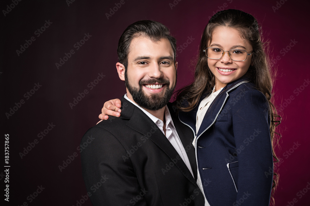 smiling father and daughter looking at camera on burgundy smiling father and daughter looking at camera on burgundy