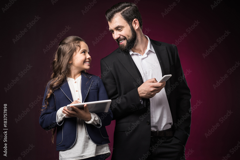 Plakat uśmiechnięty ojciec i córka z tabletem i smartfonem, patrząc na siebie w Burgundii