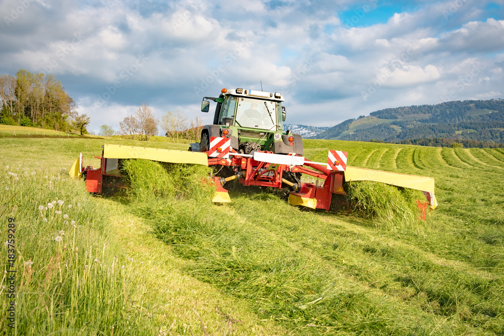 Silagewerbung - Landwirt beim Abmähen einer Wiese Silagewerbung - Landwirt beim Abmähen einer Wiese