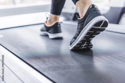 cropped shot of woman in jogging sneakers running on treadmill © LIGHTFIELD STUDIOS