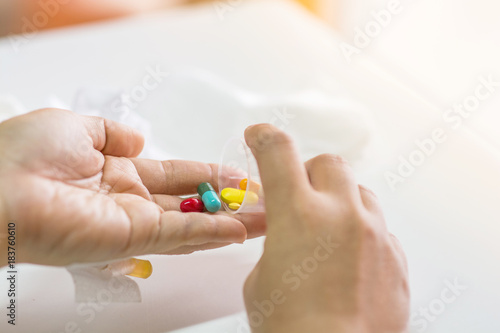 The patient handles the Cup medicine to prepare to take pill and put in hand.