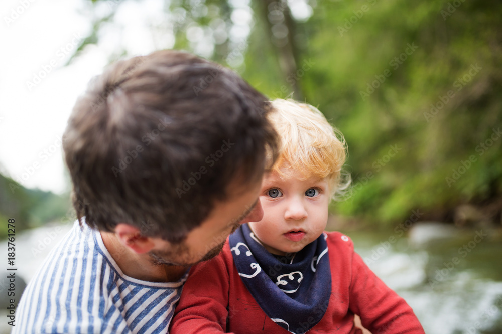 Young father with little boy at the river, summer day.