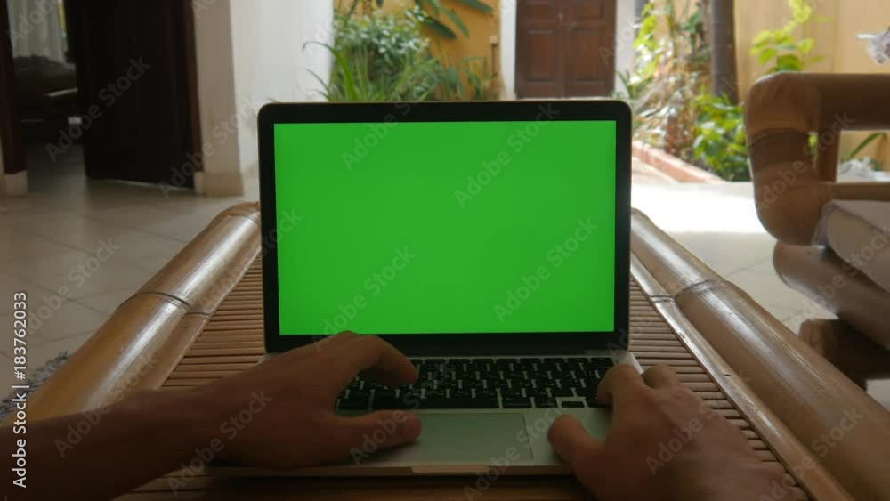 Man works at laptop at home with Green Screen. Freelancer works at home. Man works at laptop at home with Green Screen. Freelancer works at home.