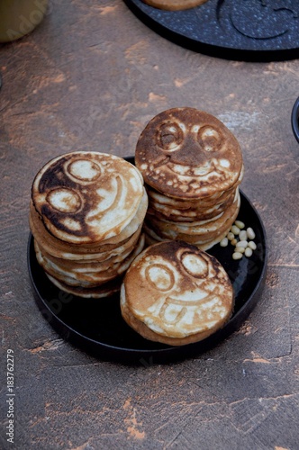 In the kitchen in a frying pan pancakes, fritters with smileys