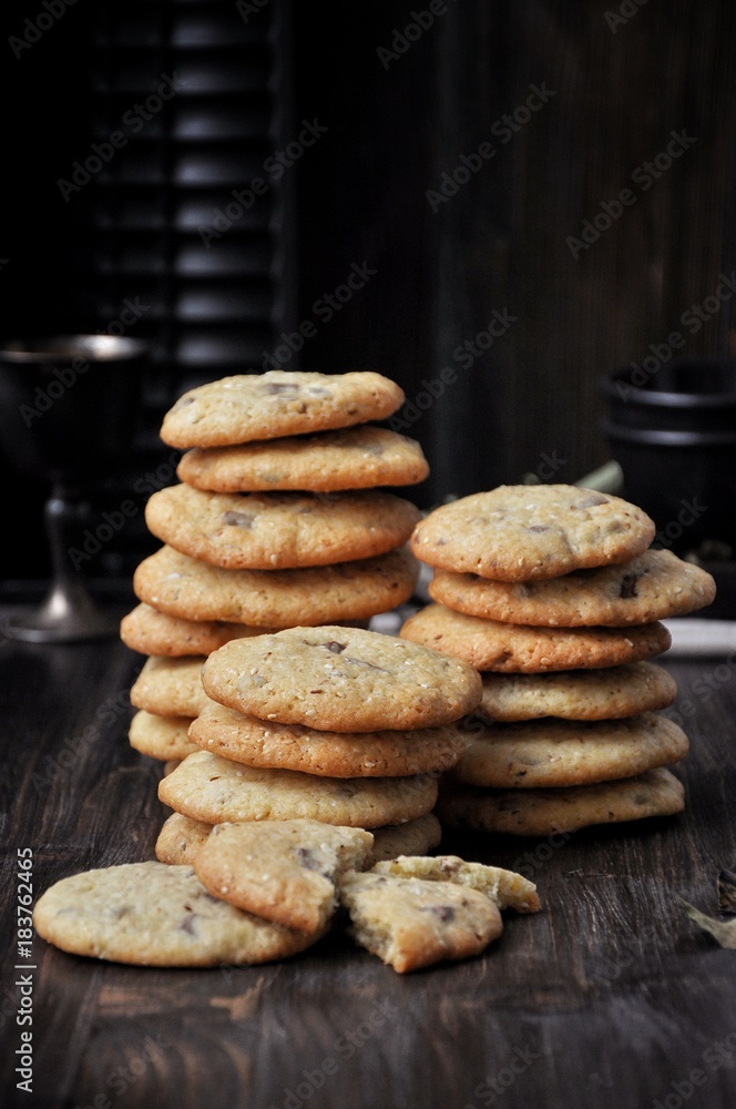 Stacks of cookies on a wooden table. Dark background