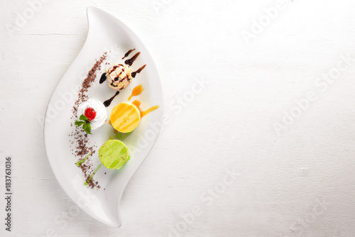 Panakota with taste of pistachio, orange, chocolate. On a wooden background. Free space for your text. Top view.