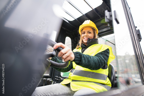 Woman forklift truck driver in an industrial area. photo