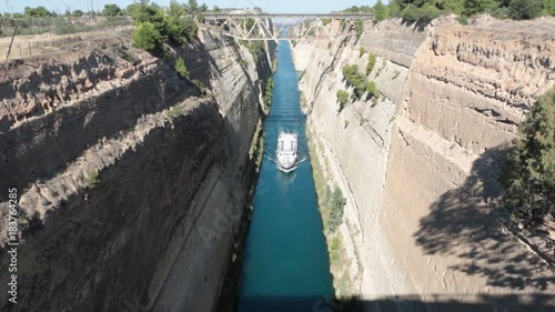 ferry boat swimming through beautiful and stunning sky blue isthmus canal in Corinth in Greece