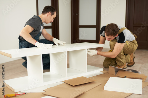 Two carpenters assembling furniture