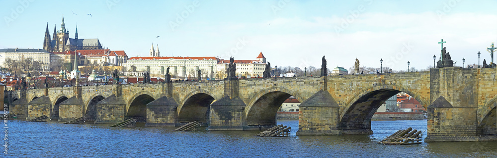 A panoramic view of the Prague Castle, Vltava river and the Charles Bridge. Unidentified tourists admiring the famous city