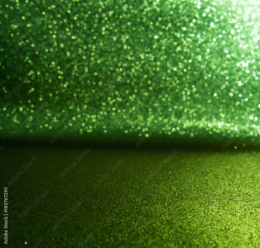 Naklejka premium green glitter lights background. defocused