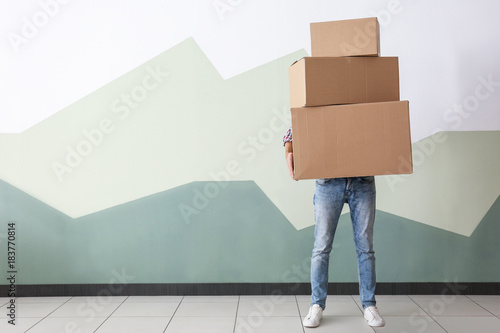 Fotografie, Obraz Man with moving boxes near color wall