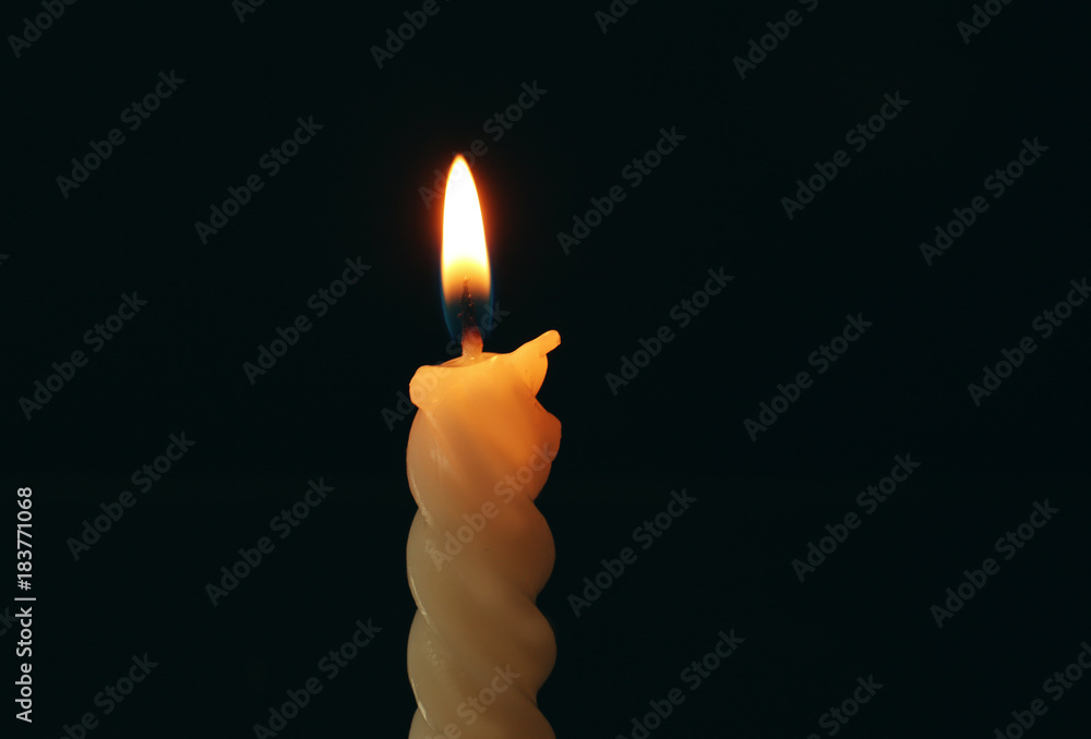 Spiral candle burning in darkness, closeup Spiral candle burning in darkness, closeup
