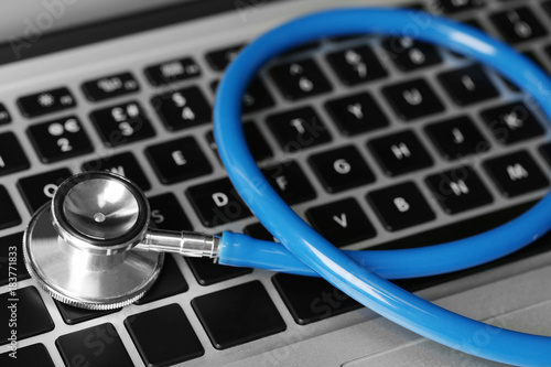 Stethoscope on laptop keyboard, closeup
