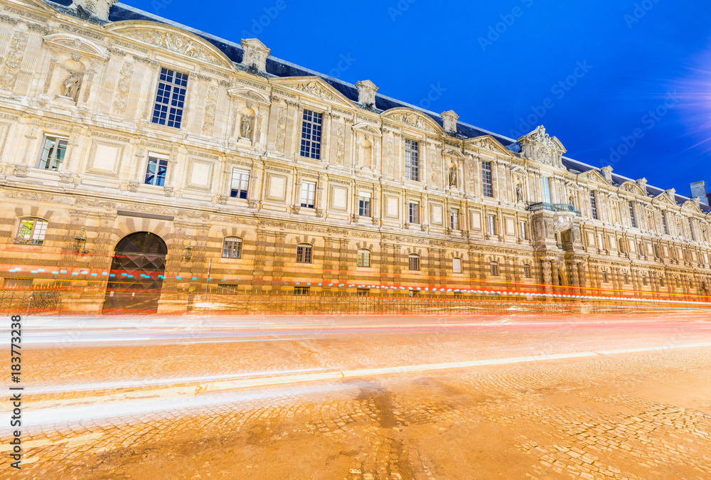 Obraz premium Ancient Paris building with car light trails, France
