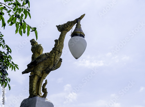 Gold bird lamp. Swan-shaped lantern with blue sky background.