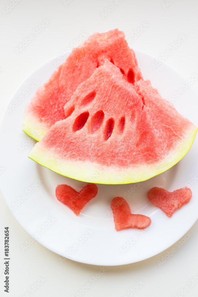 on the plate are two pieces of watermelon and a small heart-shaped on the plate are two pieces of watermelon and a small heart-shaped