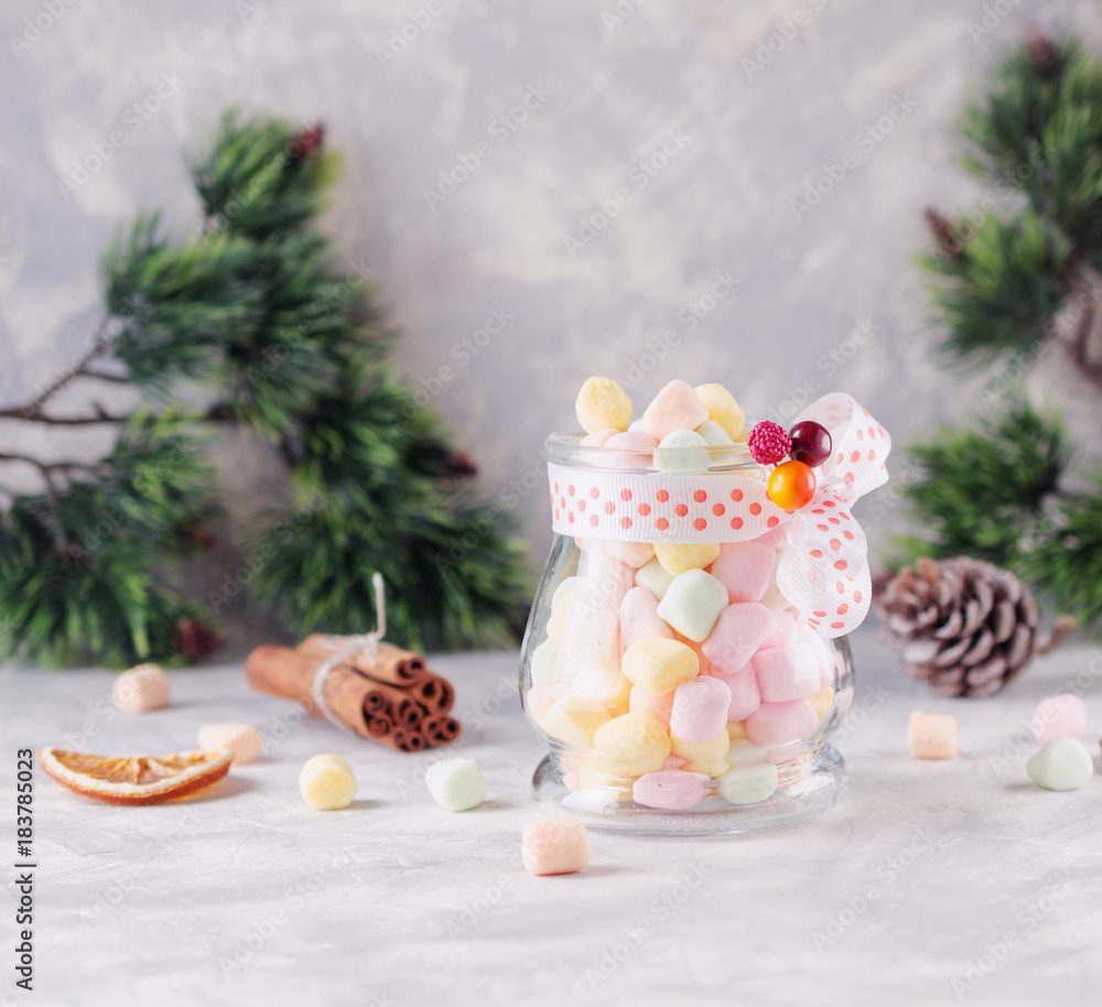 jar with marshmallows for Christmas and New Year on a wooden white table, selective focus