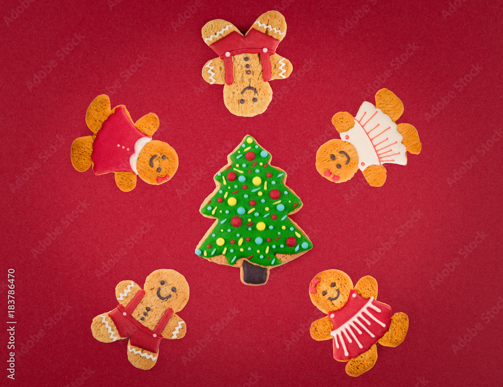 Christmas cookies of different shapes and sizes with a festive decor on a red background. Holiday Poster concept.  Empty place for a postural inscription