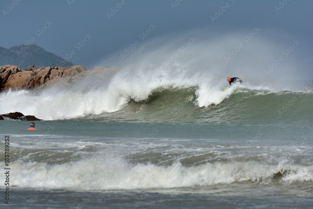Surfeur sur une vague, plage Trestraou de Perros-Guirec en Bretagne