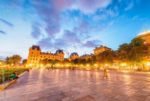 Square in front of Notre Dame with tourists at night, Paris