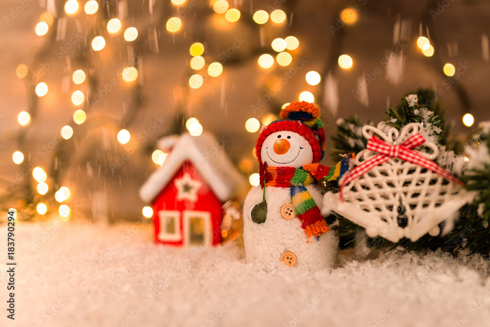Christmas decoration on a wooden background with snowman, snow and lights in the background Christmas decoration on a wooden background with snowman, snow and lights in the background