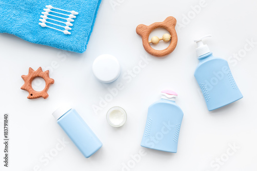 Natural bath cosmetics for kids. Bottles, towel and toys on white background top view