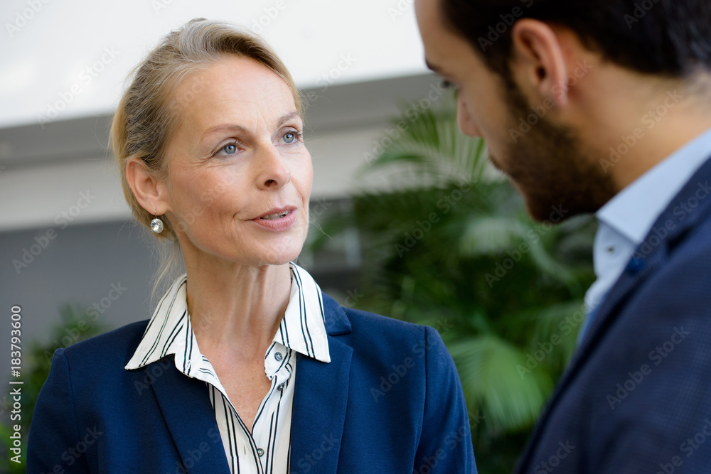 Businesswoman and man meeting in office atrium Businesswoman and man meeting in office atrium