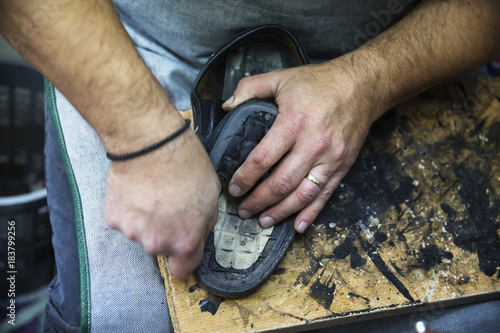 Shoemaker repairing a shoe sole in workshop