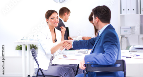 Business people shaking hands, finishing up a meeting, in office