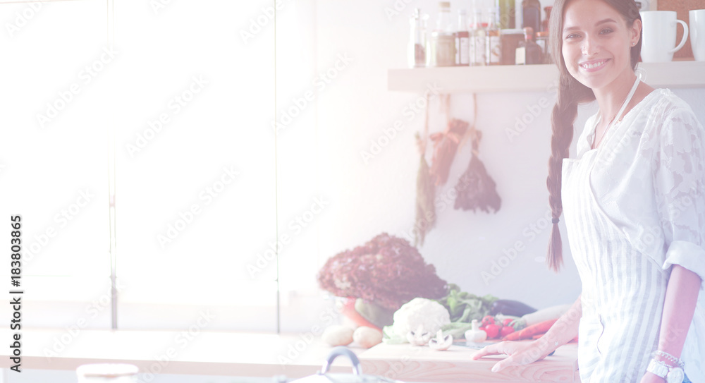 Young woman standing near desk in the kitchen Young woman standing near desk in the kitchen