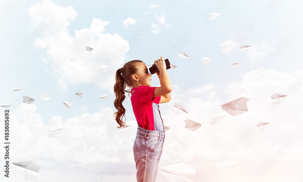 Concept of careless happy childhood with girl looking in binoculars Concept of careless happy childhood with girl looking in binoculars