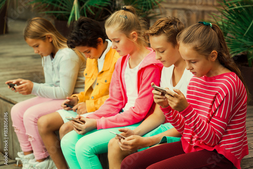 Cheerful children are chatting on their smartphone