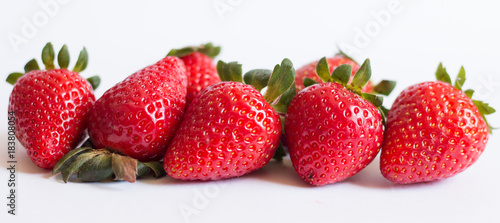 Ripe strawberries lined horizontally with white background