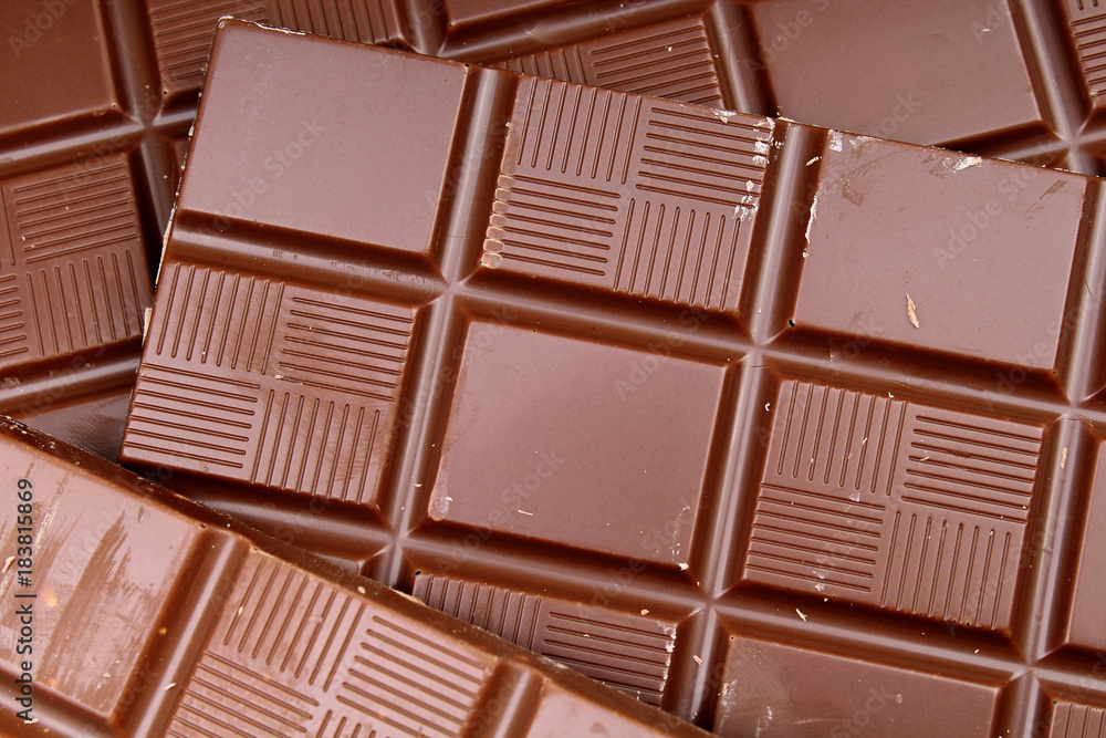 Chocolate bars as background. Milk and dark shiny chocolate texture. Stack chocolates pattern. Stunning beautiful cacao brown choco dessert sweets. Chocolate bars as background. Milk and dark shiny chocolate texture. Stack chocolates pattern. Stunning beautiful cacao brown choco dessert sweets.