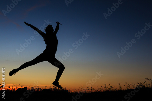 Silhouette of a woman jumping happily © erikzunec