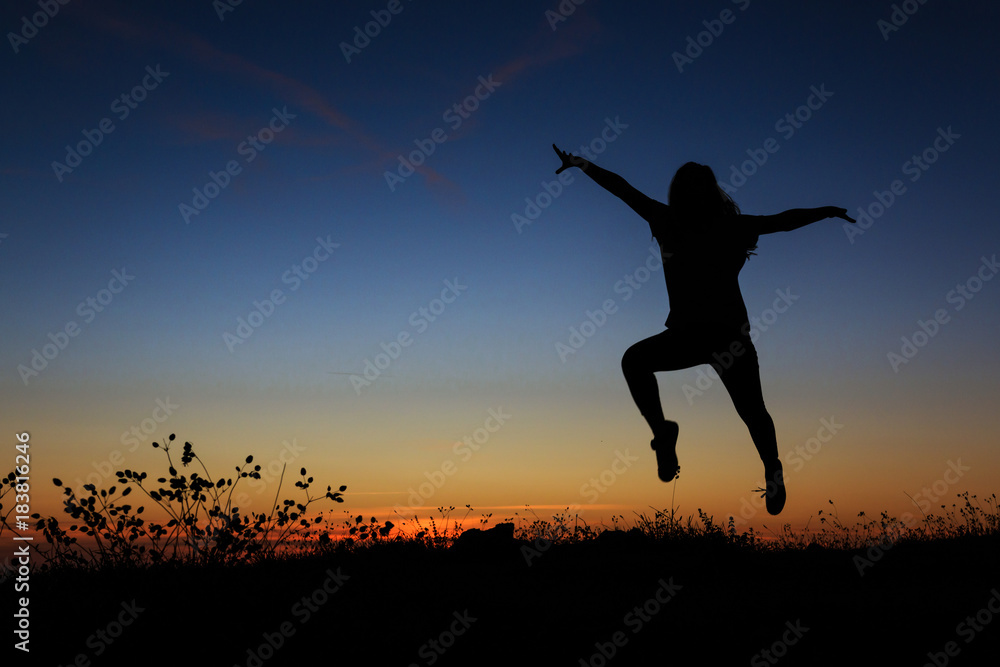 Silhouette of a woman jumping happily Silhouette of a woman jumping happily