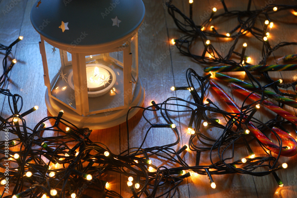 Set of white lantern with christmas lights and candy canes on the wooden floor. Set of white lantern with christmas lights and candy canes on the wooden floor.