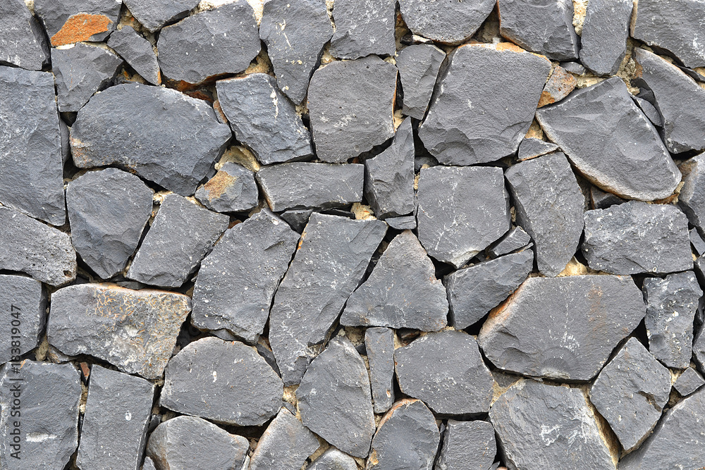 Fototapeta premium Stone wall background texture basalt rocks wall