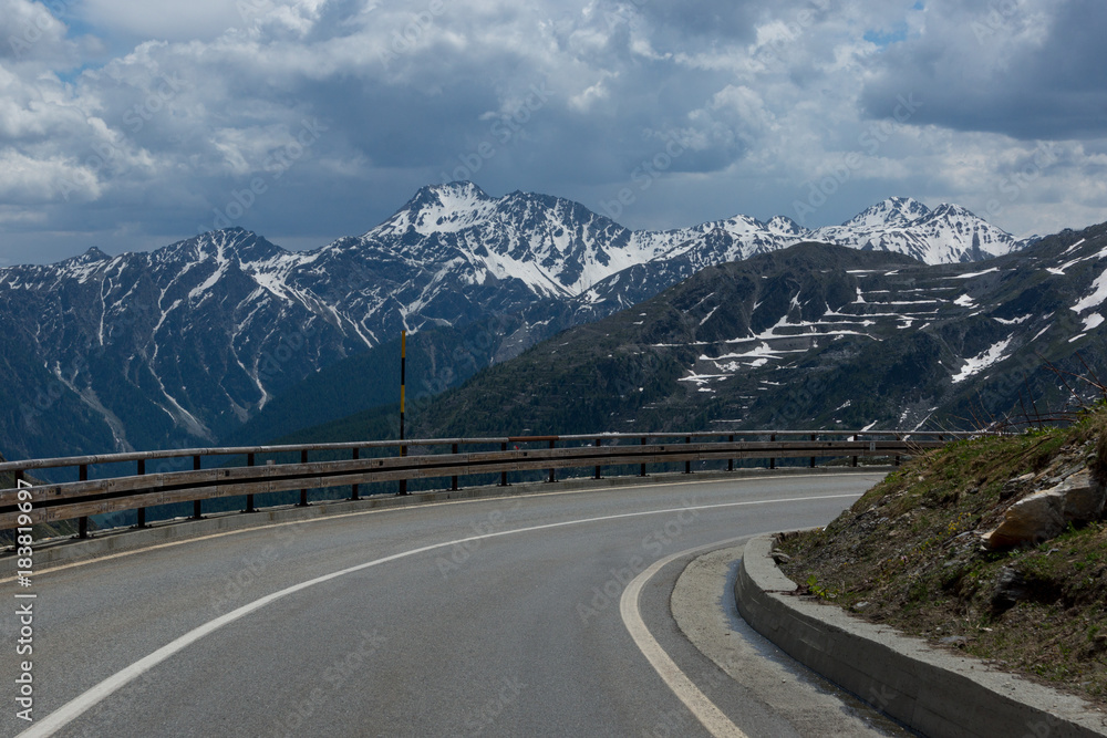 Fototapeta premium Dangerous panoramic serpentine road high in the Alps between melting snow